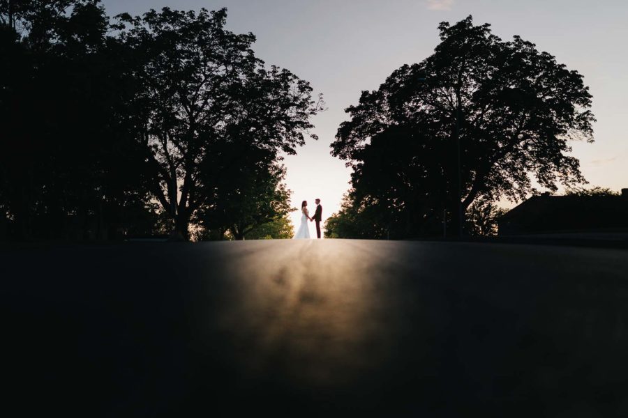 Bild på budpar i solnedgång tagen av bröllopsfotograf Oscar Edwards